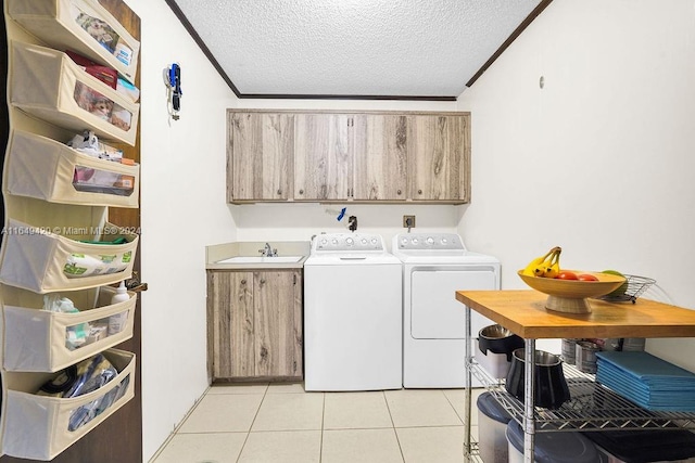 washroom featuring crown molding, a textured ceiling, cabinets, and washing machine and clothes dryer