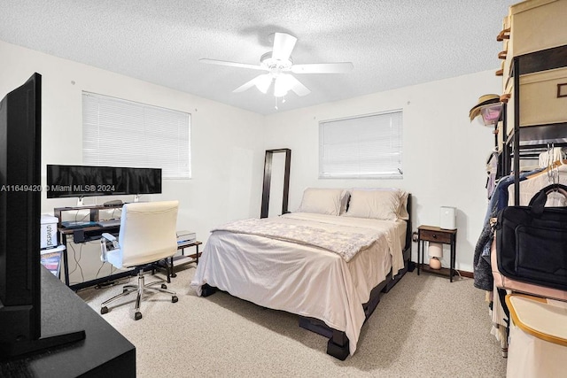 bedroom with a textured ceiling, light colored carpet, and ceiling fan