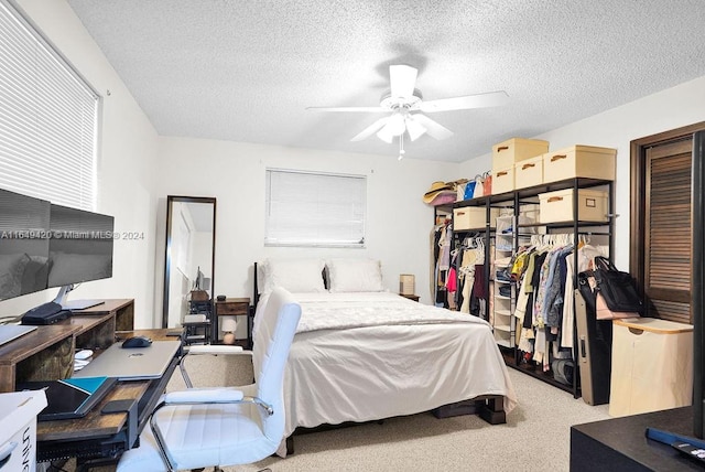 carpeted bedroom featuring ceiling fan and a textured ceiling