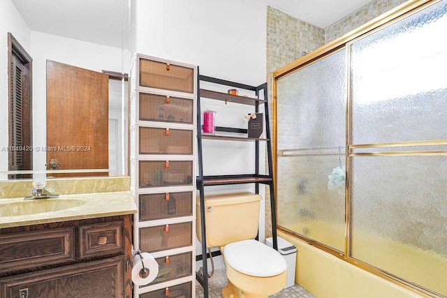 full bathroom featuring tile patterned flooring, toilet, combined bath / shower with glass door, and vanity