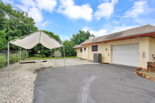 view of front of property with cooling unit and a garage