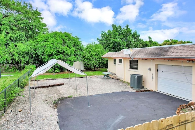 view of side of property featuring a garage and central AC