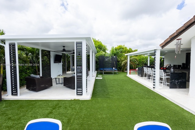 view of yard featuring a patio, a trampoline, and ceiling fan