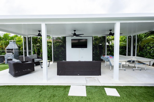 view of patio with an outdoor living space with a fireplace and ceiling fan