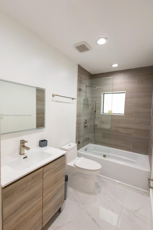 full bathroom with vanity, tiled shower / bath combo, and toilet