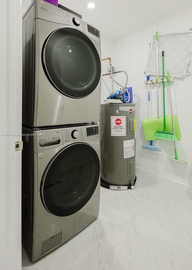 clothes washing area with electric water heater and stacked washer / dryer