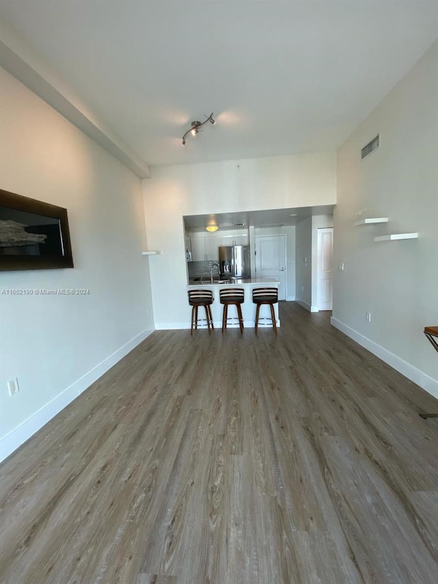 unfurnished living room with hardwood / wood-style flooring and sink