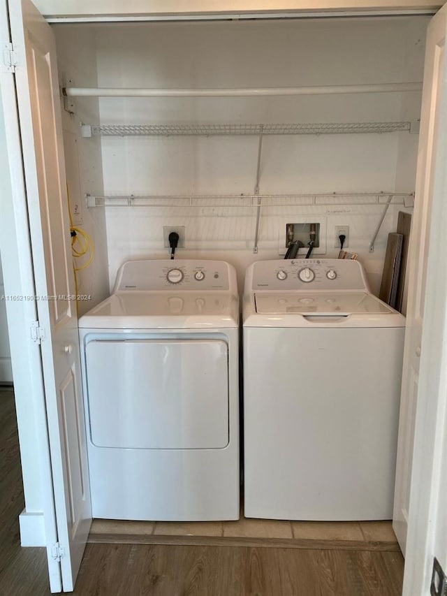 clothes washing area featuring dark wood-type flooring and independent washer and dryer