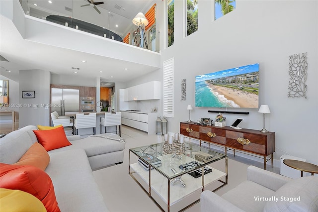 living room with a high ceiling and ceiling fan