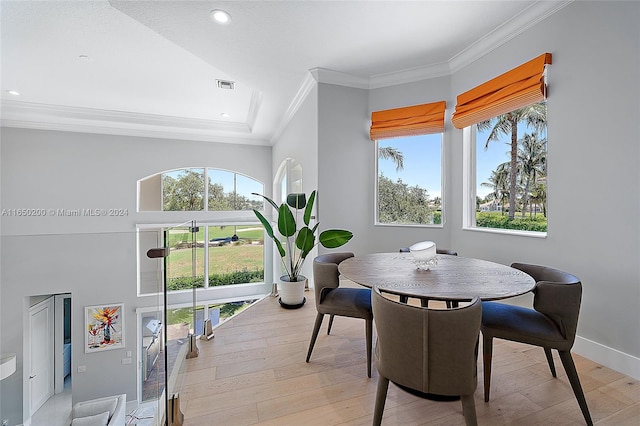 dining room featuring light hardwood / wood-style flooring, crown molding, and a wealth of natural light