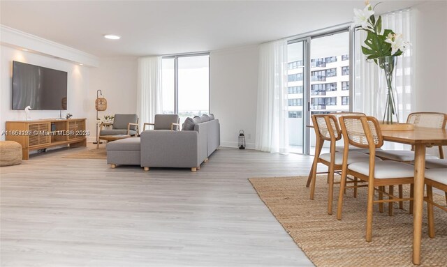 living area with light wood-type flooring, a wall of windows, and recessed lighting