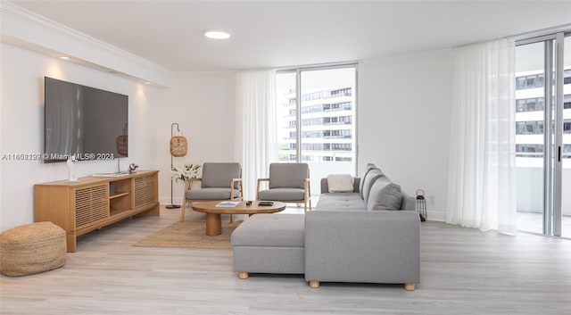 living room with light wood-type flooring, ornamental molding, and a wall of windows