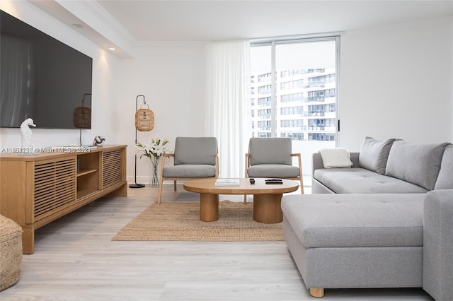 living room featuring ornamental molding, floor to ceiling windows, plenty of natural light, and light hardwood / wood-style flooring