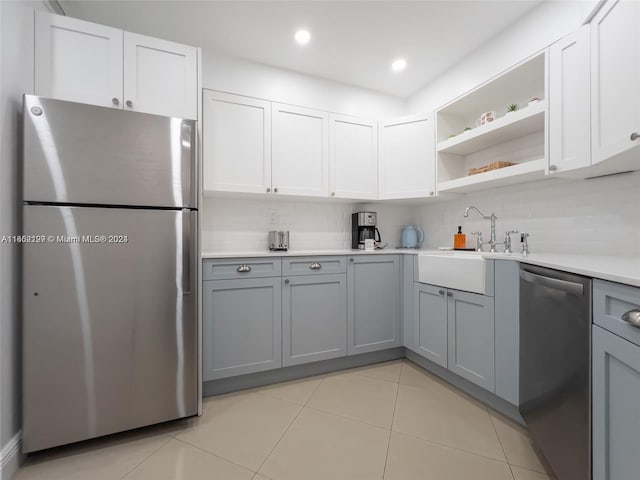 kitchen with light countertops, stainless steel appliances, open shelves, and gray cabinets