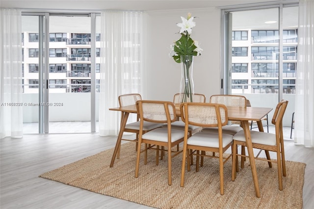dining room featuring ornamental molding, wood finished floors, and a healthy amount of sunlight