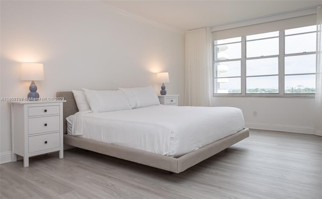 bedroom featuring light hardwood / wood-style floors and crown molding