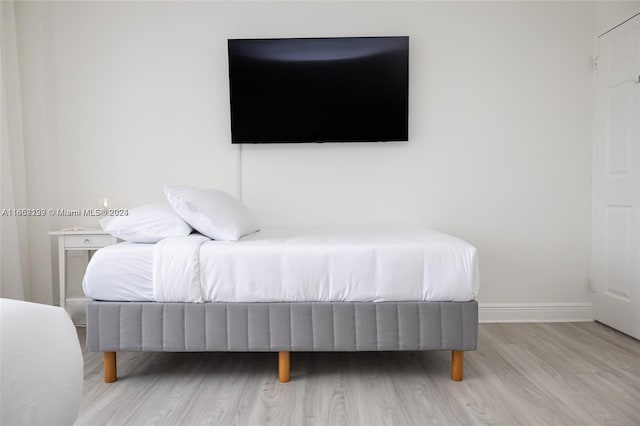 bedroom with wood finished floors and baseboards
