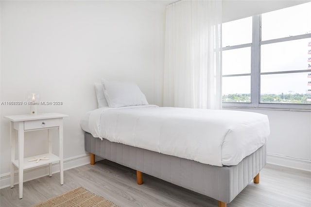 bedroom with light wood finished floors and baseboards