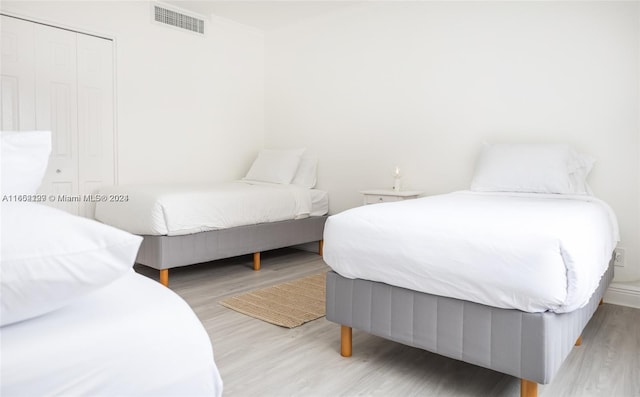 bedroom featuring visible vents and wood finished floors