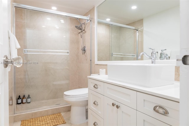 bathroom featuring vanity, toilet, walk in shower, and tile patterned flooring