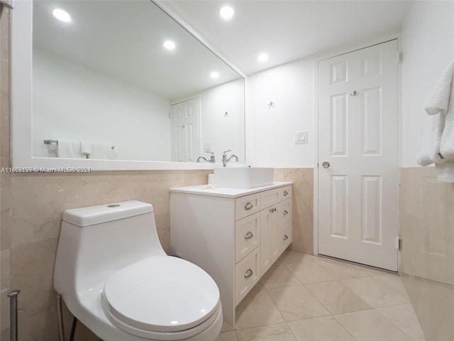 bathroom with tile walls, toilet, vanity, recessed lighting, and wainscoting