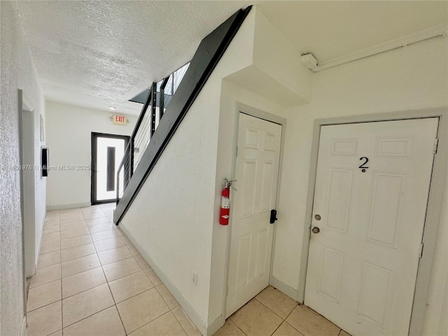 foyer with light tile patterned flooring and a textured ceiling