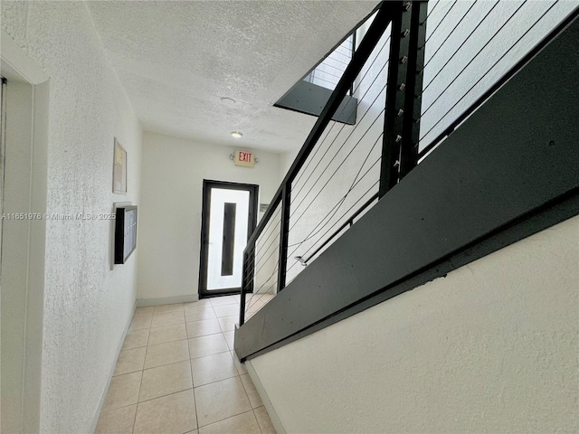 staircase featuring a textured ceiling and tile patterned floors