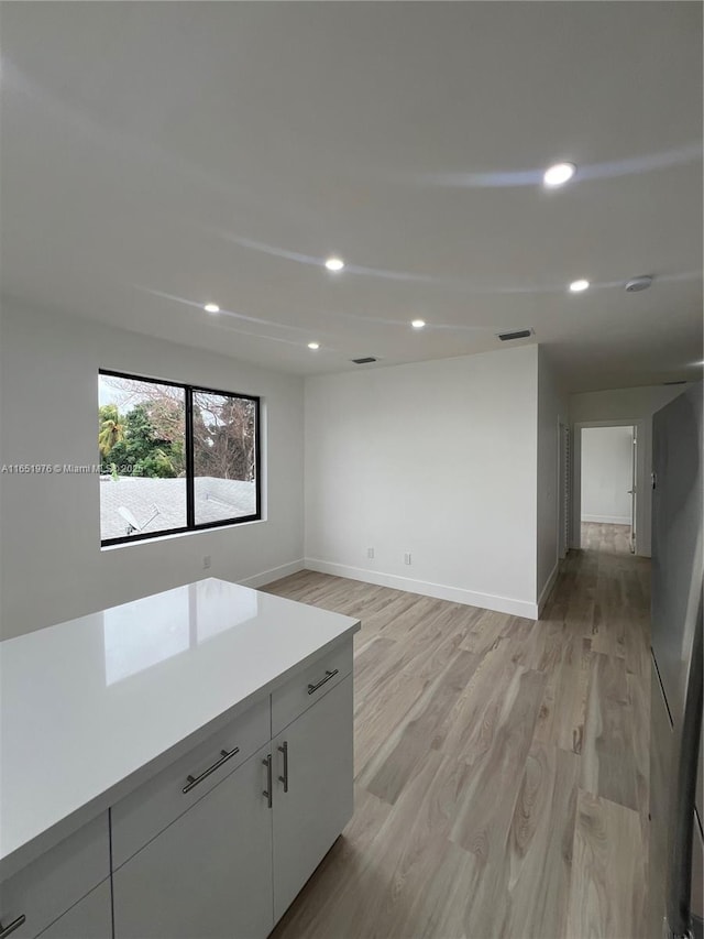 kitchen featuring white cabinets and light hardwood / wood-style flooring