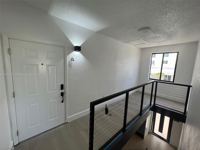 hall featuring a textured ceiling