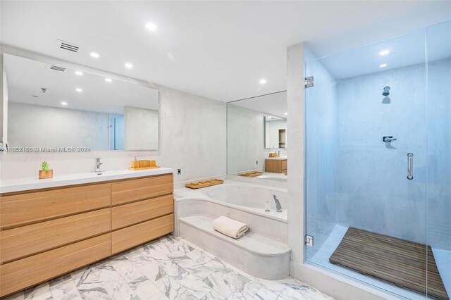 bathroom with vanity and separate shower and tub