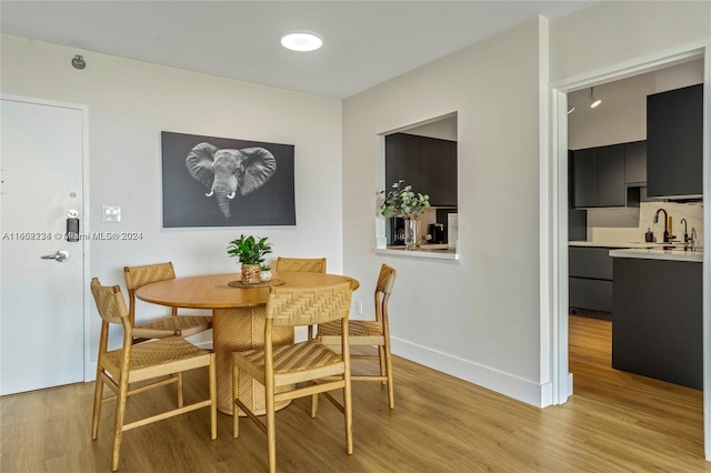 dining area with light wood-type flooring and sink