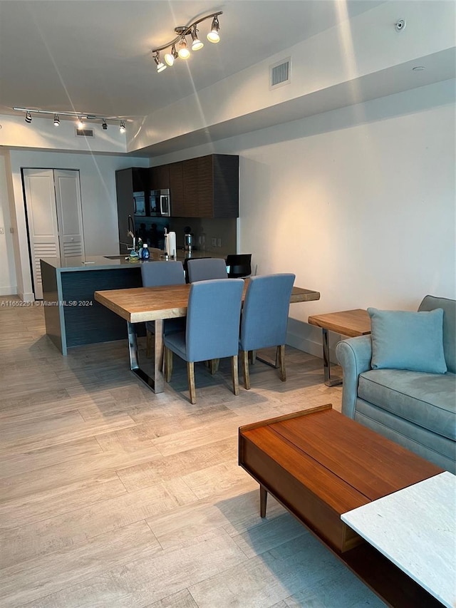 interior space featuring track lighting, sink, and light hardwood / wood-style floors