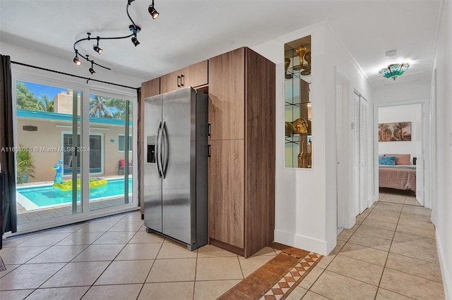 2320 SW 36th Ave, Fort Lauderdale, FL 33312 - kitchen with light tile patterned floors, brown cabinets, rail lighting, glass insert cabinets, and stainless steel fridge