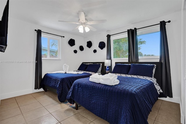 tiled bedroom featuring multiple windows and ceiling fan