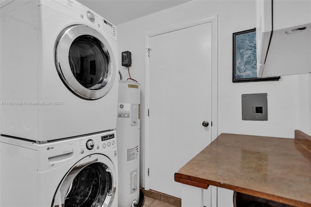 clothes washing area with electric water heater, light tile patterned floors, and stacked washer and clothes dryer