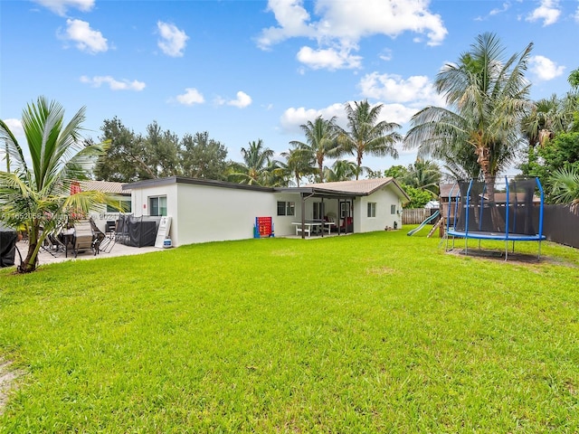 view of yard with a trampoline, a playground, and a patio