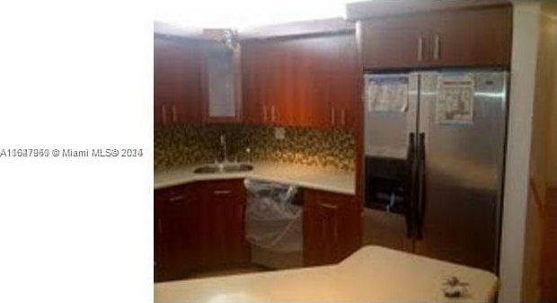 kitchen with stainless steel appliances, sink, and tasteful backsplash