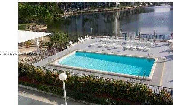 view of swimming pool featuring a patio and a water view