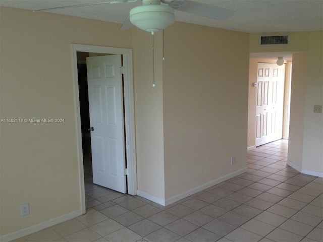 tiled spare room with ceiling fan