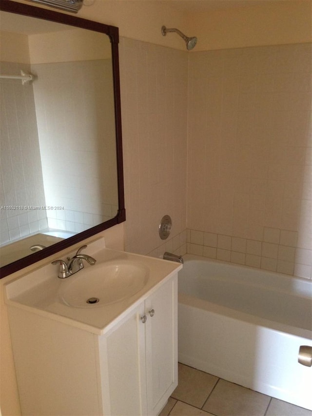 bathroom featuring tile patterned flooring, vanity, and tiled shower / bath