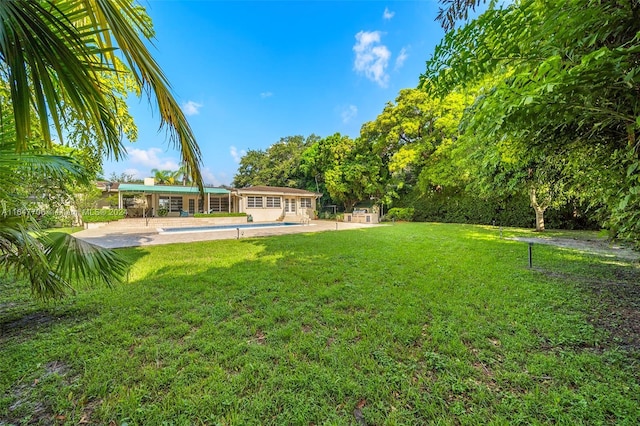 view of yard with an outbuilding, a pool, and a patio