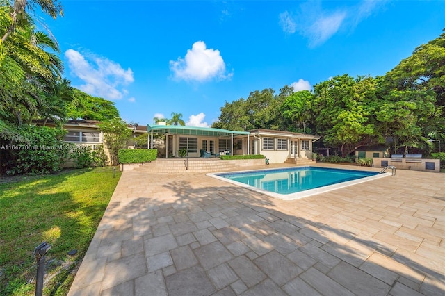 view of pool with a lawn, area for grilling, and a patio