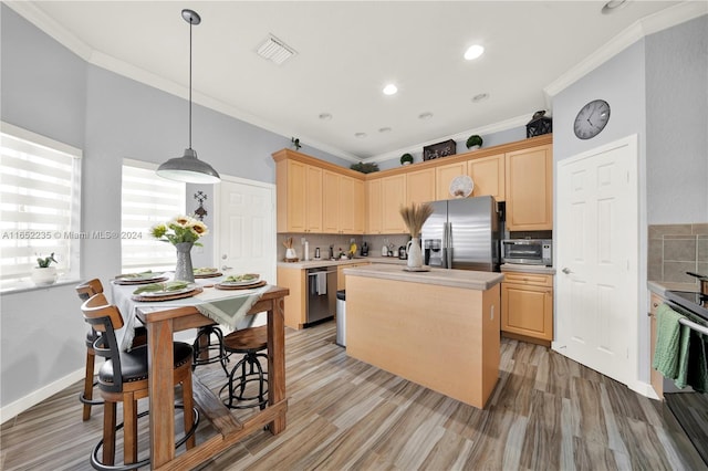 kitchen with light brown cabinets, appliances with stainless steel finishes, crown molding, and light hardwood / wood-style floors