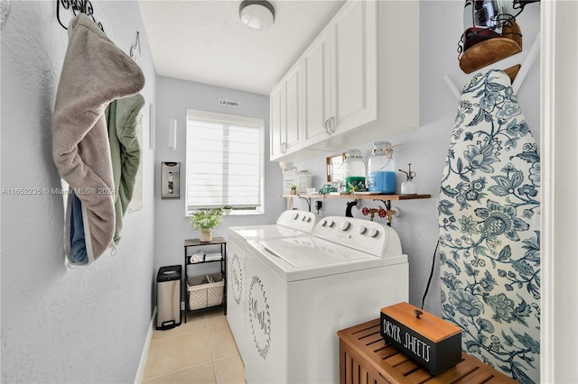 washroom with light tile patterned flooring, separate washer and dryer, and cabinets