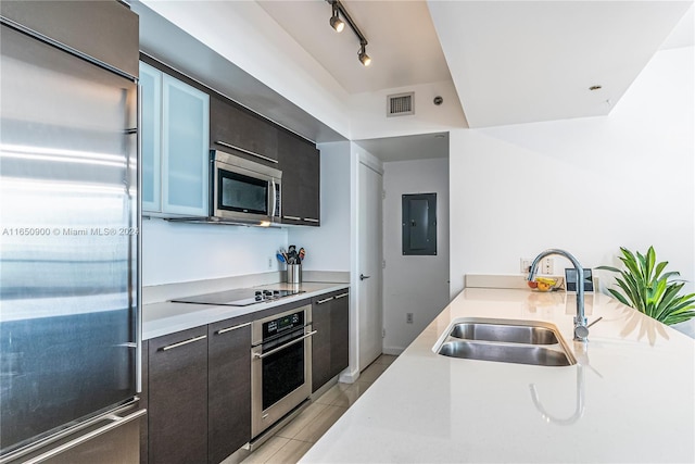 kitchen featuring sink, light tile patterned floors, appliances with stainless steel finishes, and track lighting