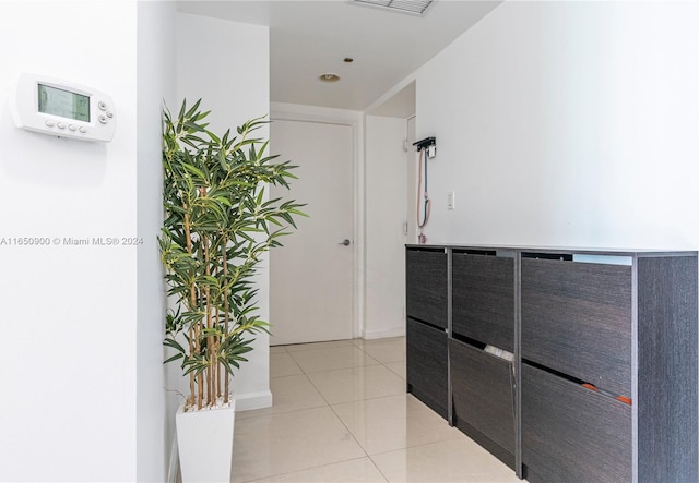 hallway featuring light tile patterned floors and visible vents