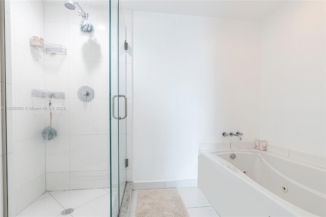 bathroom with baseboards, a whirlpool tub, a shower stall, and tile patterned flooring