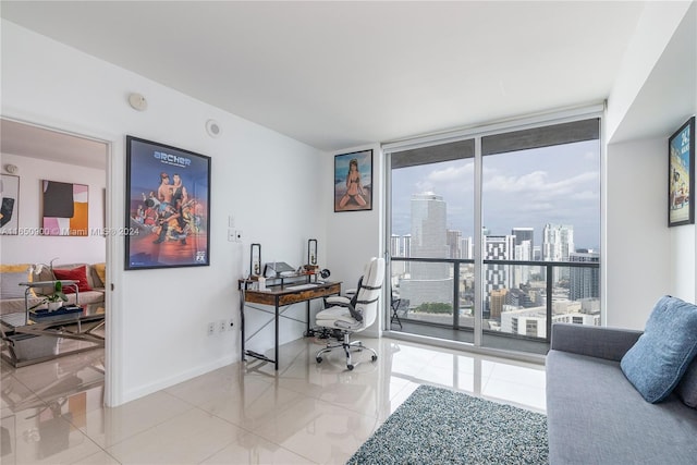 tiled office space featuring a city view, baseboards, and expansive windows