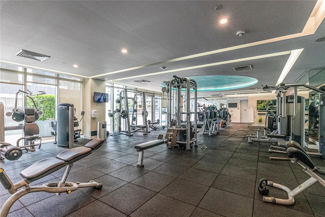 workout area featuring recessed lighting, visible vents, and expansive windows