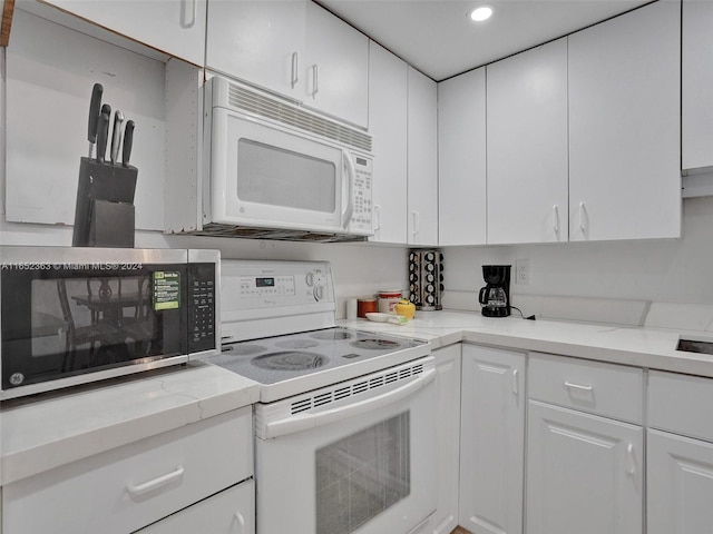 kitchen featuring white cabinetry and white appliances